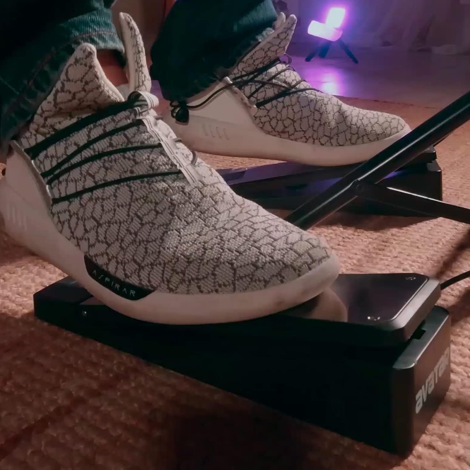 Foot pressing down on an Avatar hihat/bass pedal for PD705 and PD708 in a dimly lit room setting.