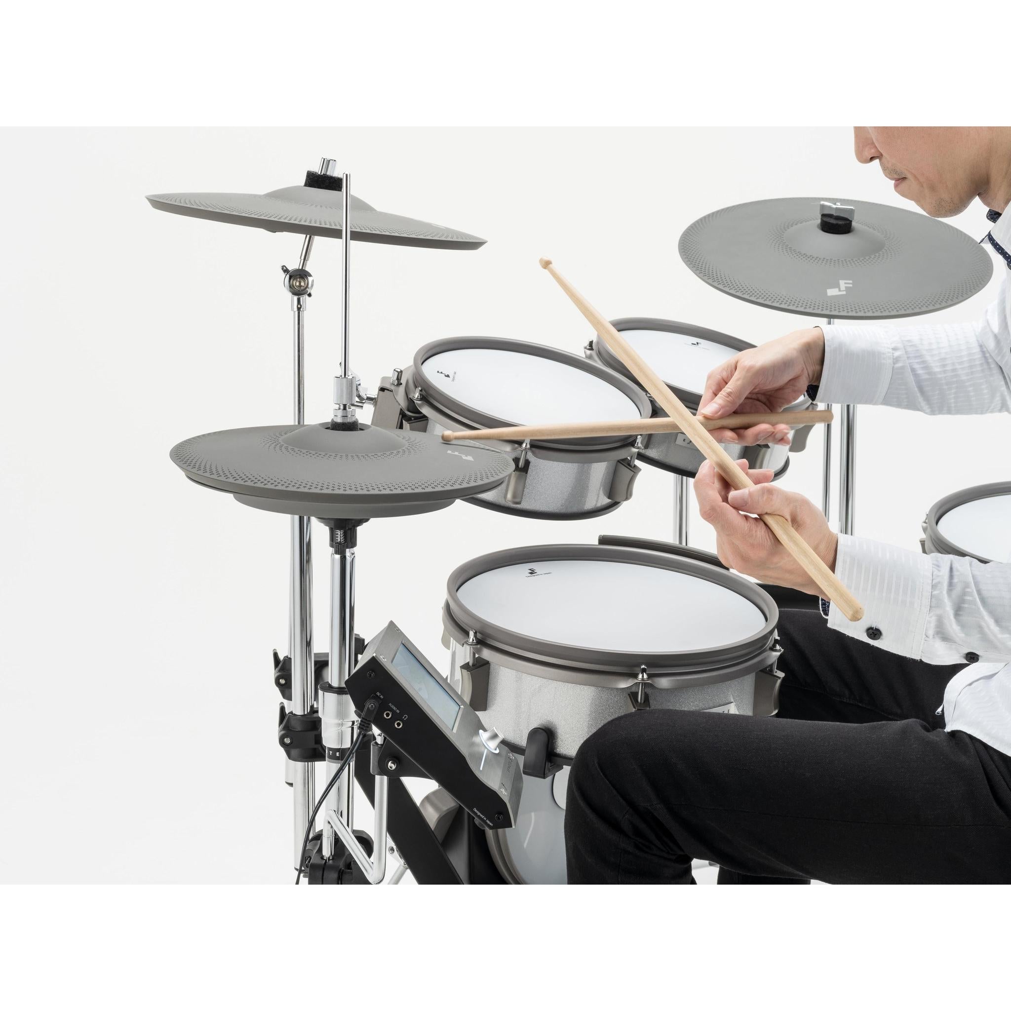 Person playing EFNOTE 3 Style-A electronic drums with cymbals and drumsticks in a compact setup