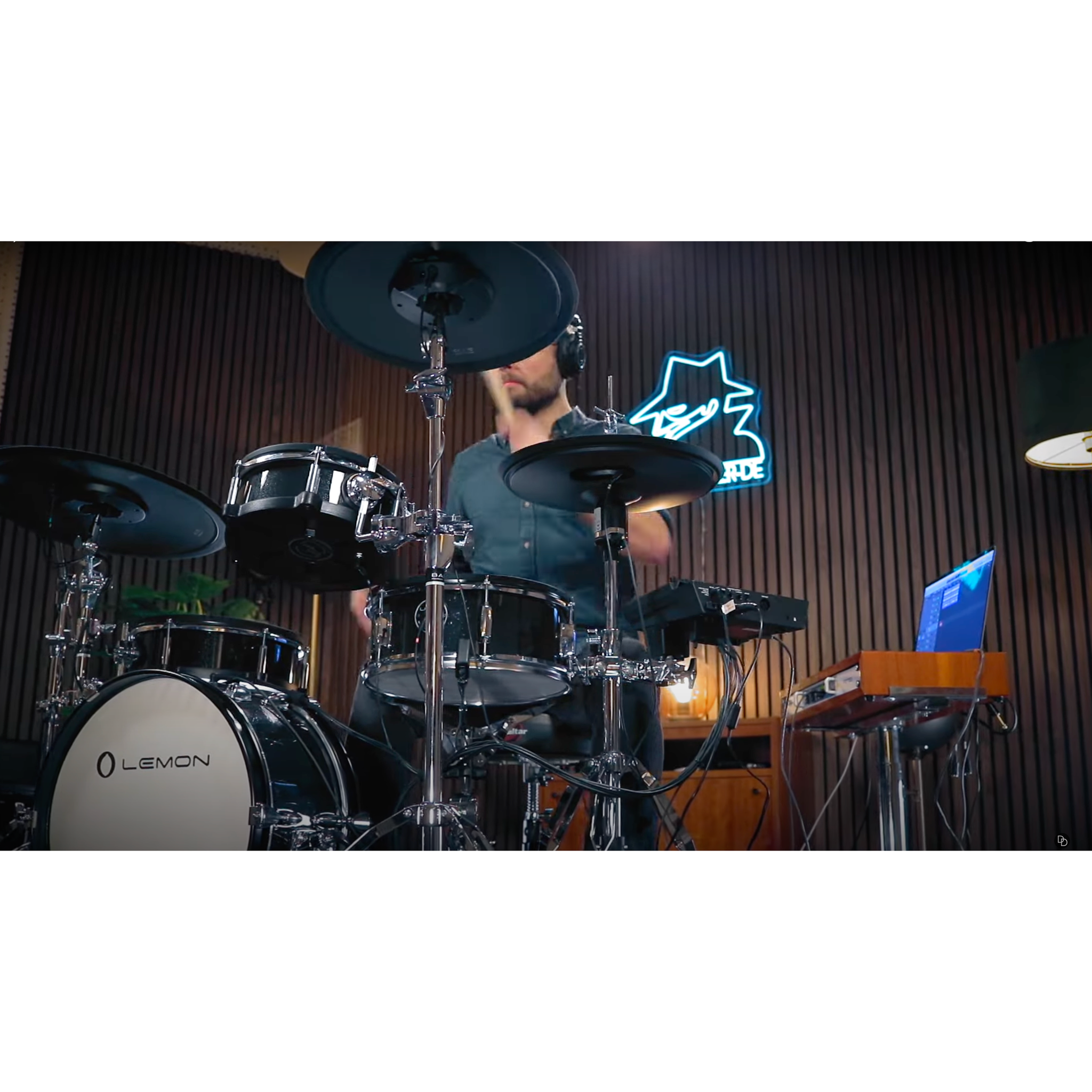 Drummer playing Jack Lemon drum kit with black sparkling shells and SpareDrum hardware in studio setting.