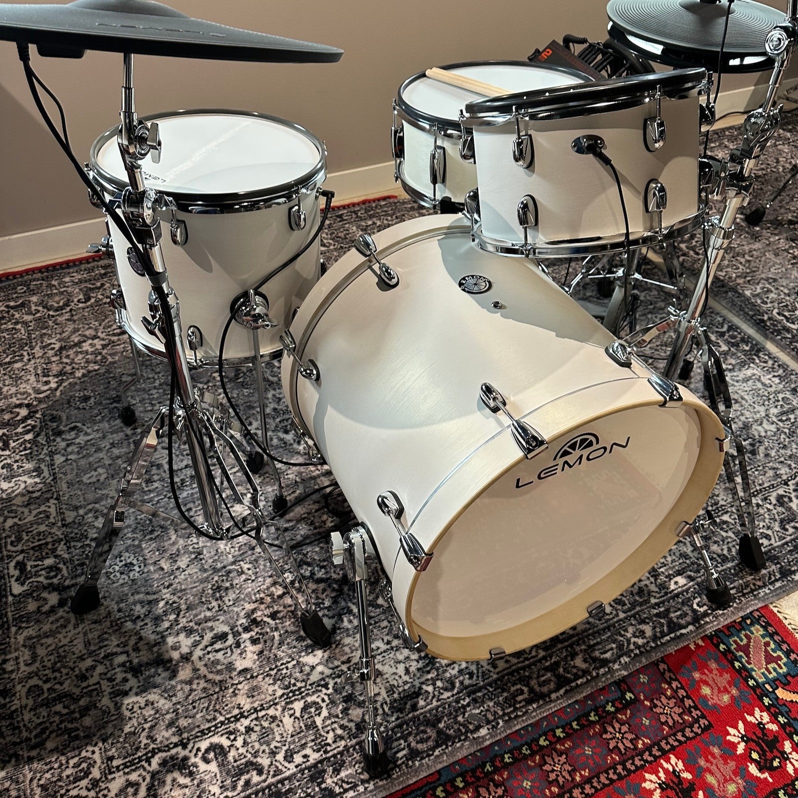 Lemon 12 inch wooden mesh head tom mounted on drum set with white drum shells and chrome hardware