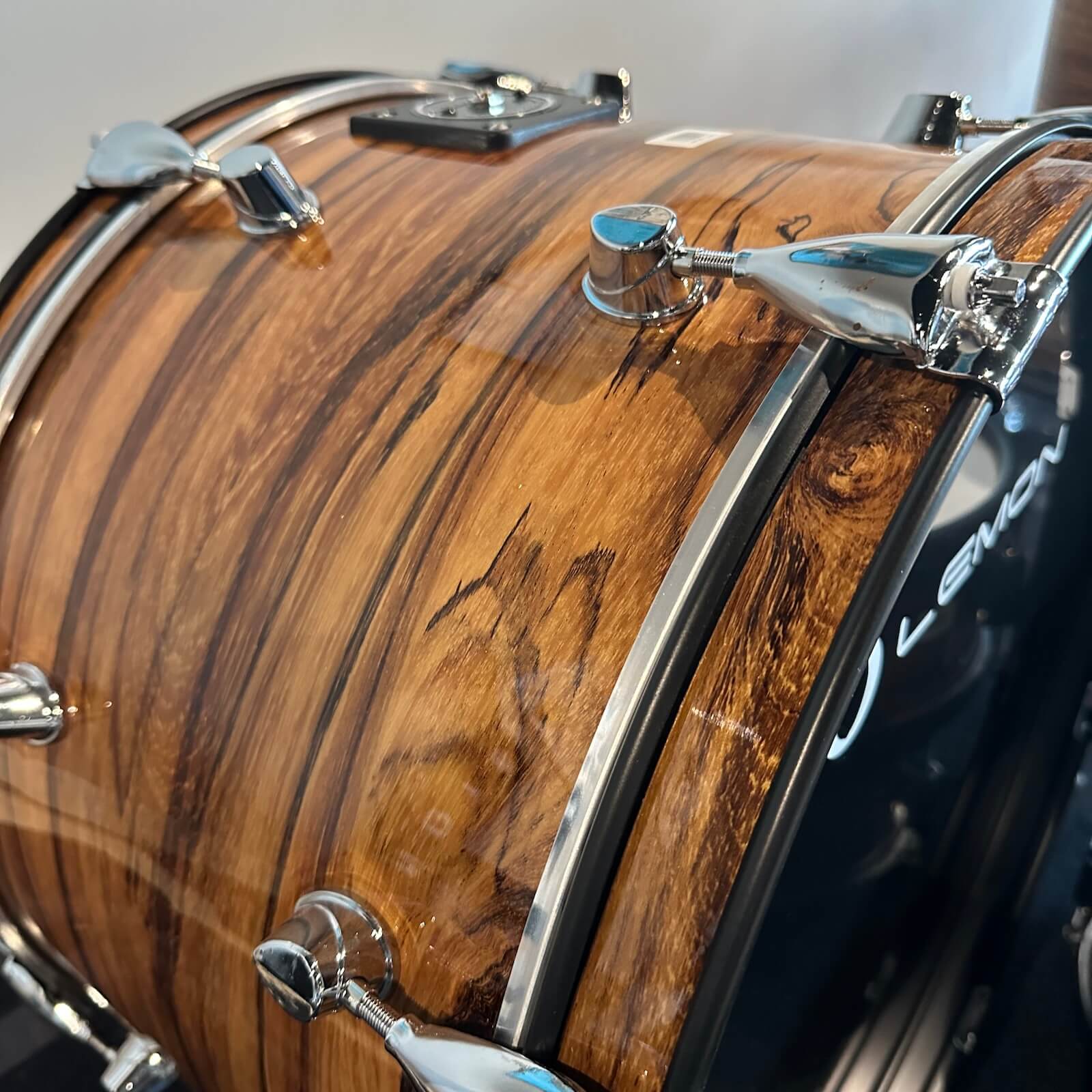 Close-up of warm dark brown wooden shells with chrome hardware on Lemon Dark Wood Grain rock e-drum shell set by Lemon
