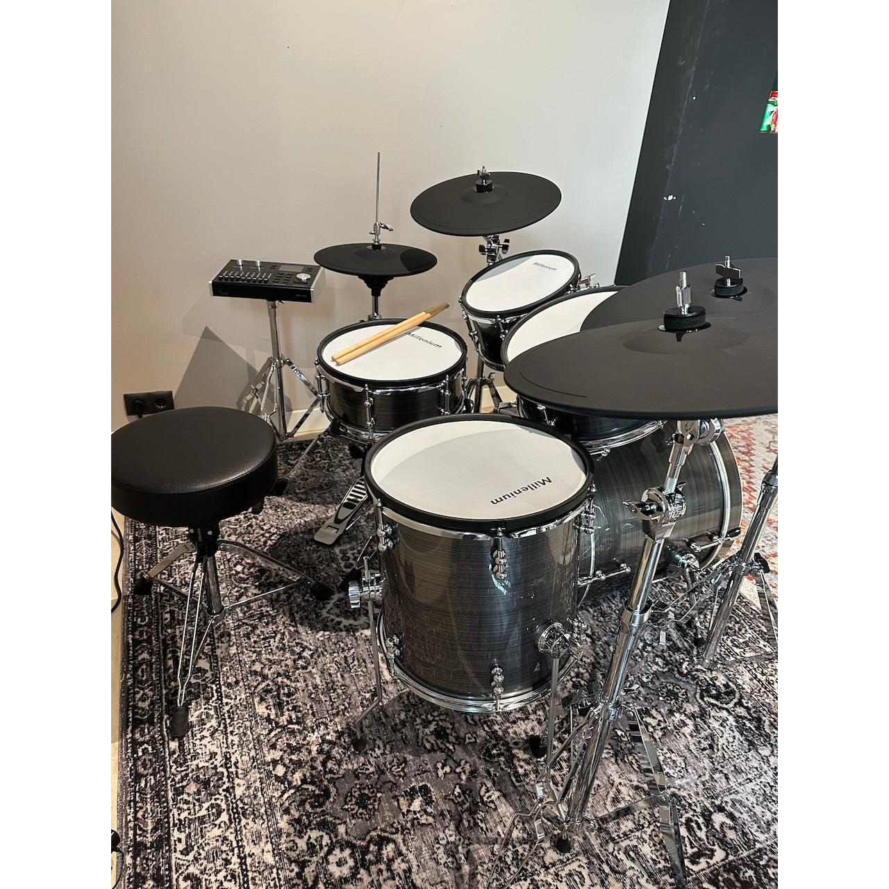 Millenium MPS-1000 E-Drum set (Pre-Owned) with real wooden shells and modern black drum pads on a patterned rug.