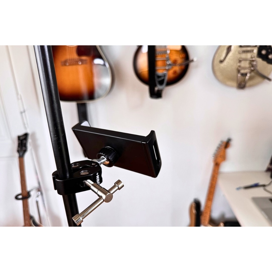 NBO Universal Tablet/Phone Holder mounted on a black stand with guitars hanging in the background