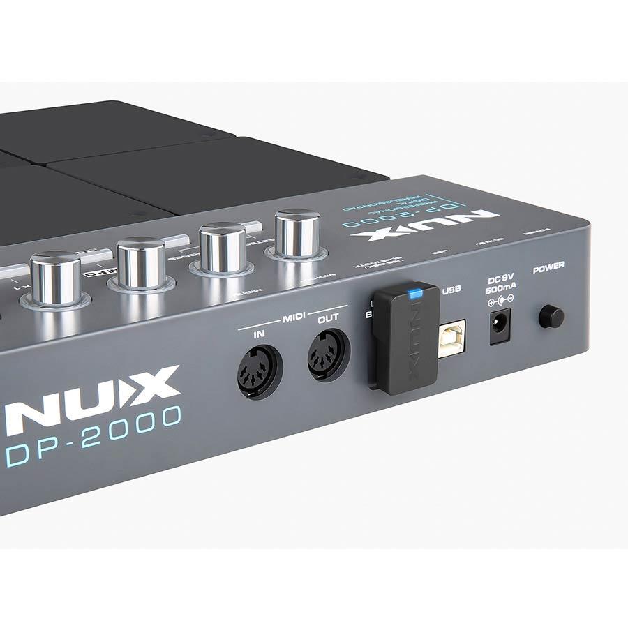 Close-up of NUX DP-2000 Digital Percussion Pad showing MIDI ports, USB connection, control knobs, and power switch